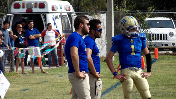 El HC César García dialogando con su quarterback durante el juego