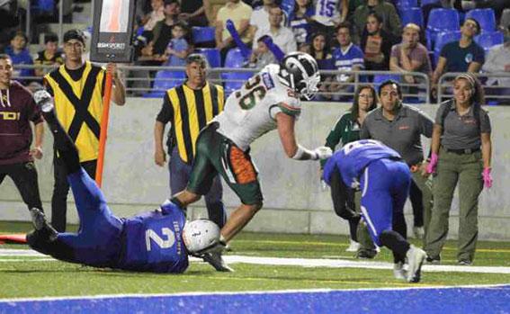 Kevin Correa (26) anota el primer TD para Aztecas, al superar las tackleadas de Mauricio Martínez (2) y Rubén Cueva (43).